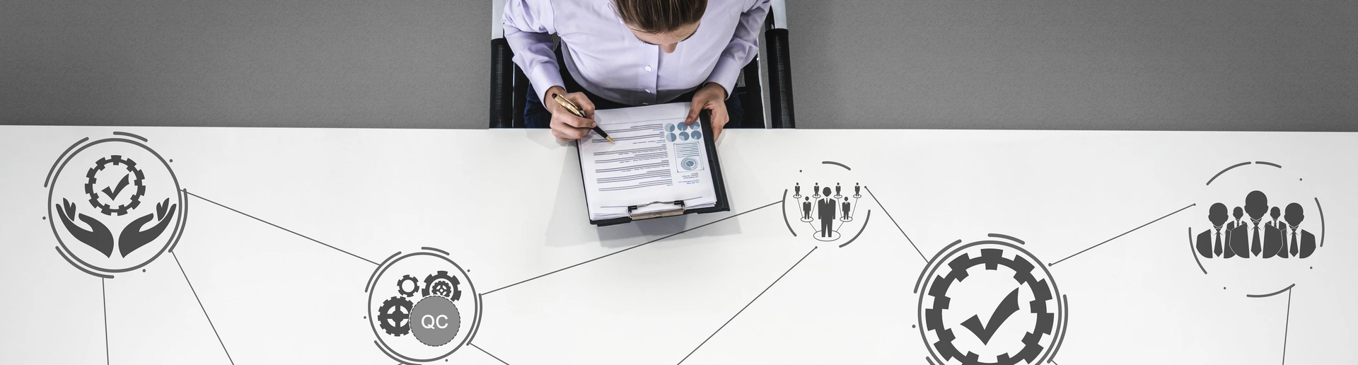 Frau am Tisch mit Qualitätmanagement Icons