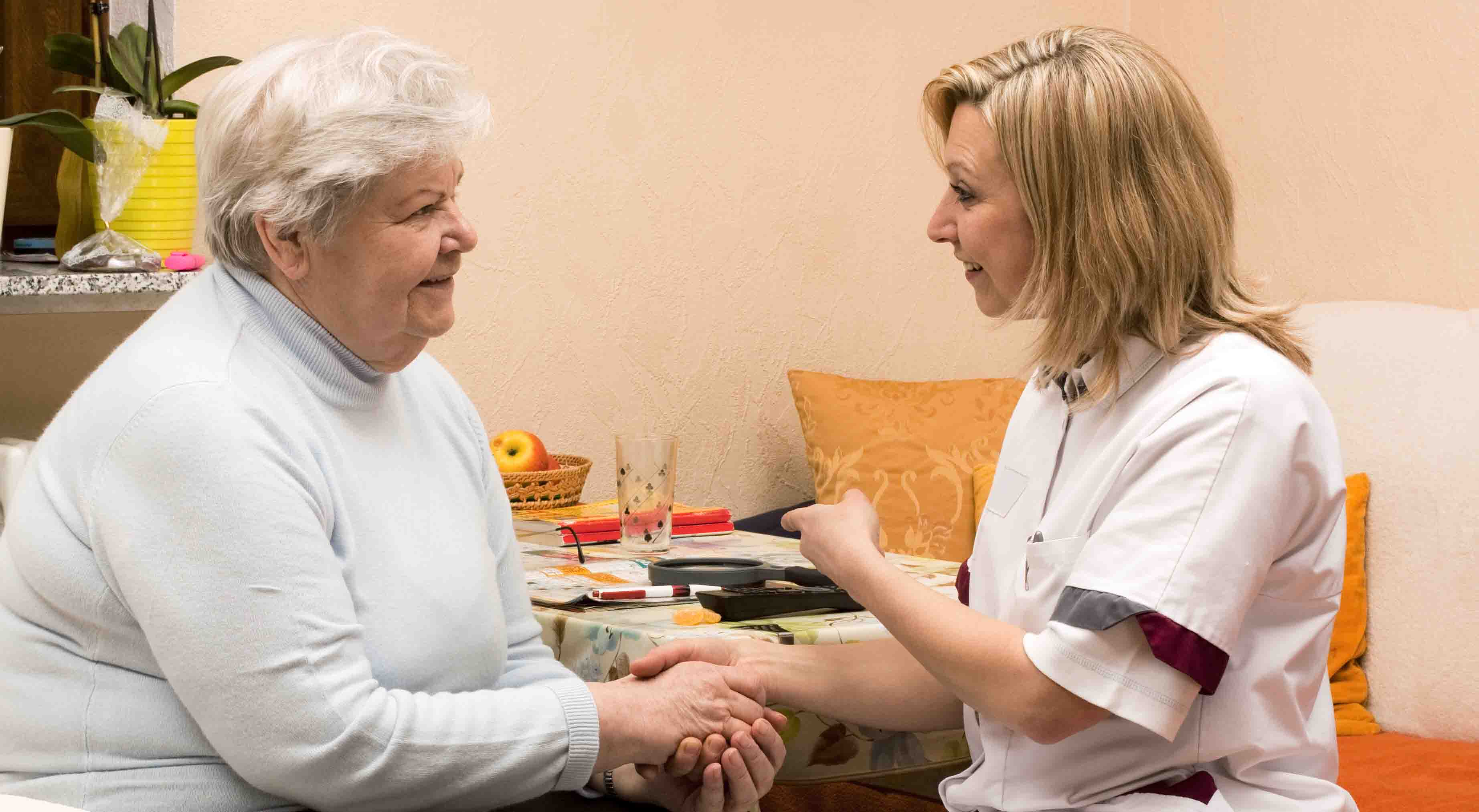 Ältere Patientin und Medizinische Fachangestellte bei einem Hausbesuch
